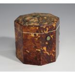 An early 19th century tortoiseshell tea caddy of octagonal form, the hinged lid and sides with metal