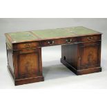 A 20th century reproduction mahogany twin pedestal desk, fitted with drawers and cupboards, on