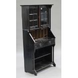 An Arts and Crafts ebonized bureau bookcase, the moulded pediment above a pair of glazed panel