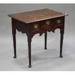 An early 18th century oak lowboy, the moulded top above three drawers and a shaped apron, raised