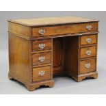 An early 19th century camphor and crossbanded kneehole desk, the moulded top above a drawer