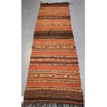 A Kurdish flatweave runner, early 20th century, the terracotta field with overall geometric