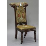 A mid-Victorian rosewood prie-Dieu chair, the seat and back upholstered in a Gothic style foliate