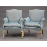 A pair of 20th century reproduction scroll armchairs, upholstered in pale blue fabric, raised on