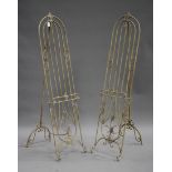 A pair of modern wrought metal garden easels of arched form with foliate scroll mounts, height