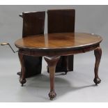 A George V mahogany oval extending dining table, the moulded top with two extra leaves, raised on