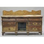 An early 20th century French pine sideboard, the shaped back above drawers and an open shelf, on