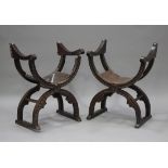 A pair of late 19th century oak 'X' frame chairs with carved rosettes and brown leather seats,