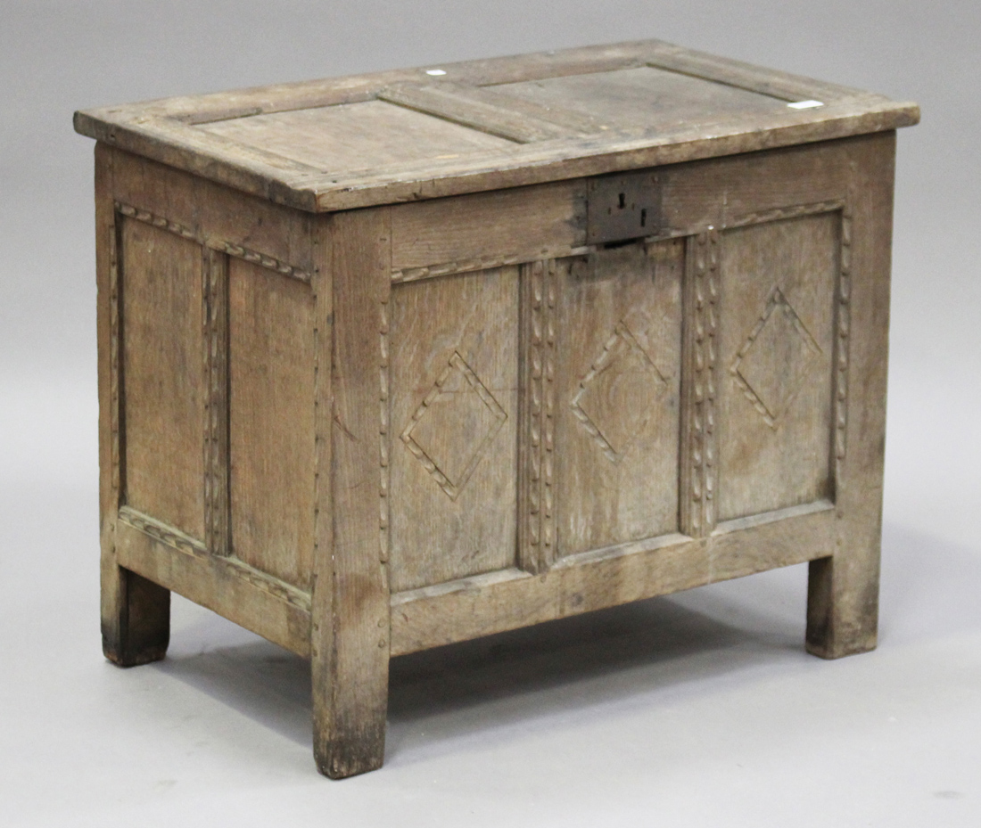 An 18th century oak panelled coffer of small proportions, the hinged lid and sides with chip