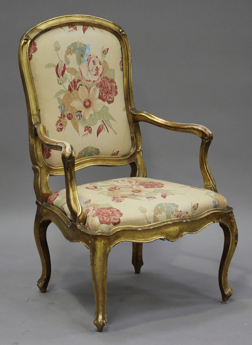 An 18th century Italian giltwood showframe armchair with an upholstered seat and back, raised on