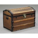 A late 19th/early 20th century wooden bound dome top travelling trunk, fitted with carrying handles,