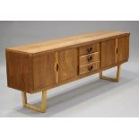 A mid-20th century teak sideboard, fitted with central drawers flanked by cupboards, raised on