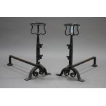 A pair of 20th century wrought iron fire dogs with scroll mounts and arched bracket feet, height