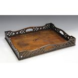 A George III mahogany tea tray, the raised gallery with pierced fretwork decoration, length 57cm.