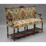 An early 20th century French walnut framed hallway settee, upholstered in floral velour, raised on