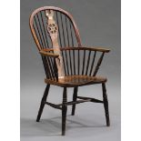 A 19th century yew and elm stick and wheel back Windsor armchair, the solid seat raised on turned