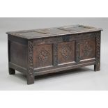 An 18th century oak triple panel coffer, the hinged lid revealing a candlebox above a carved