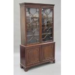 A late 19th century mahogany bookcase cabinet, the dentil moulded pediment above a pair of