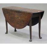 A George III mahogany oval drop-flap supper table, raised on turned tapering legs and pad feet,