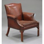 A 20th century George III style brown leather scroll armchair with studwork decoration, raised on