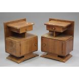 A pair of 20th century French Art Deco walnut bedside cabinets, fitted with drawers above cupboards,
