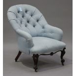 A mid-Victorian mahogany tub back salon armchair, upholstered in blue fabric, raised on carved