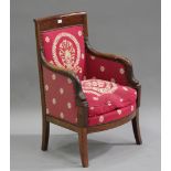 An early 19th century mahogany armchair, the upholstered seat and back flanked by carved Regency