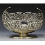 An Edwardian silver boat shaped sugar bowl with pierced scroll rim above embossed stylized scallop