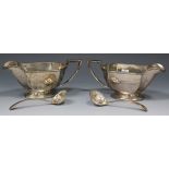 A pair of George V silver sauce boats, each of rectangular faceted form with an angular handle, on a