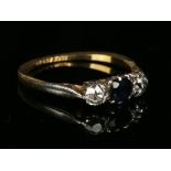 A gold, platinum, sapphire and diamond three stone ring, mounted with the oval cut sapphire