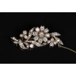 A Victorian diamond brooch, designed as a floral and foliate spray, mounted with cushion shaped