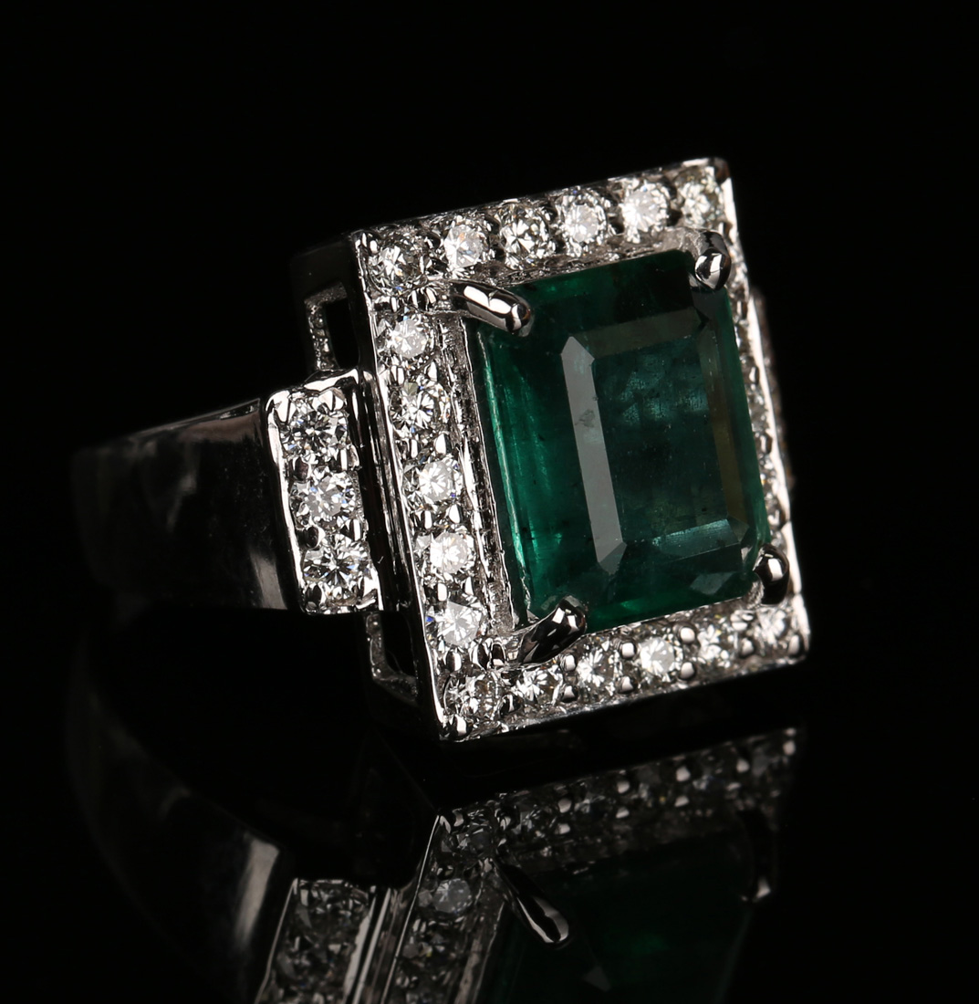 A white gold, emerald and diamond rectangular cluster ring, claw set with the rectangular step cut