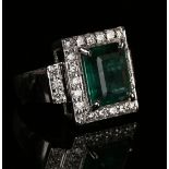 A white gold, emerald and diamond rectangular cluster ring, claw set with the rectangular step cut