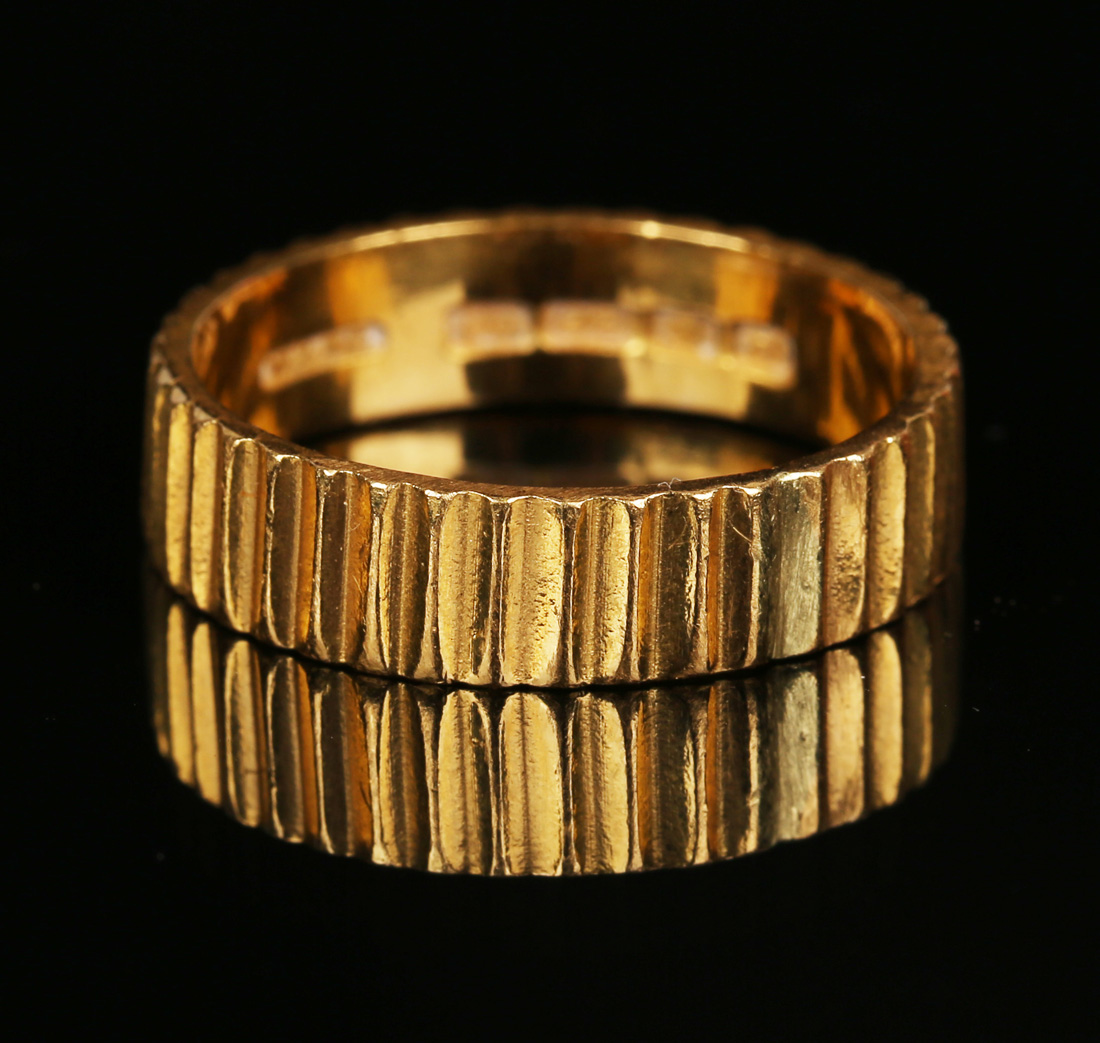 A 22ct gold wedding ring with ridged decoration, London 1959, ring size approx U.Buyer’s Premium