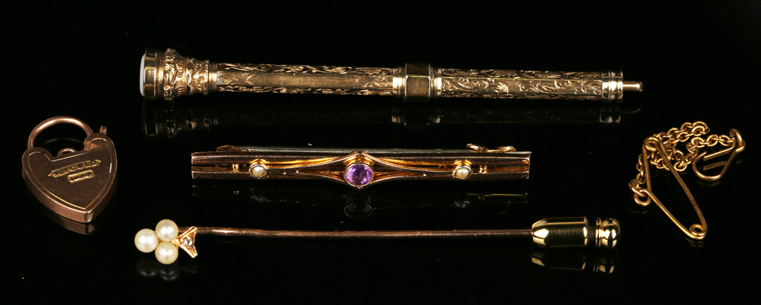 A gold, amethyst and seed pearl bar brooch, mounted with the circular cut amethyst between two