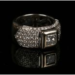 A white gold and diamond wide band ring, mounted with the principal princess cut diamond between