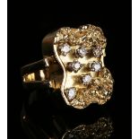 A gold and diamond curved panel shaped ring in an abstract cast design, claw set with seven circular