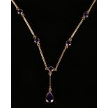 A 9ct gold and amethyst necklace, the front with a pear shaped amethyst drop, otherwise in a bar