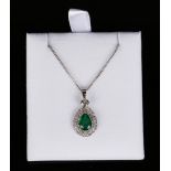 An 18ct white gold, emerald and diamond pendant, claw set with a drop shaped emerald within a two