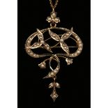 A gold and seed pearl pendant brooch in a shaped oval openwork design with foliate motifs, length
