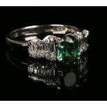 An 18ct white gold, green tourmaline and diamond set ring, claw set with an oval cut green