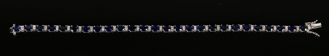 An 18ct white gold, sapphire and diamond bracelet, claw set with oval cut sapphires alternating with