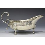 A George III Irish provincial silver sauce boat with pinched rim and foliate capped flying scroll