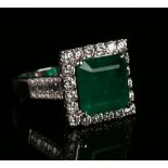 An 18ct white gold, emerald and diamond square cluster ring, claw set with a square cut emerald