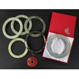 A collection of six reconstituted vari-coloured jade bangles, including one with hinged side, and