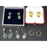 A pair of gold and colourless gem set earrings, each in the form of a stylized gloved hand,
