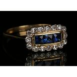 A gold, sapphire and diamond ring, mounted with a row of three square cut sapphires within a