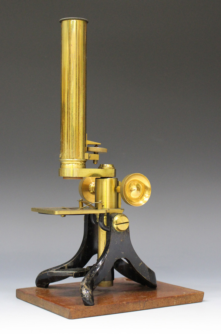 A late 19th century lacquered and black enamelled brass monocular microscope, unsigned, with rack