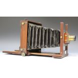 A late 19th century mahogany and lacquered brass folding plate field camera with black leather