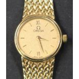 An Omega 9ct gold lady's bracelet wristwatch, the signed circular textured gilt dial with gilt baton